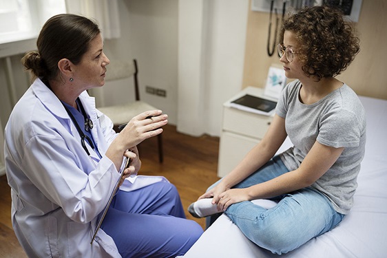 female doctor talking to teen girl